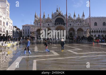 In Venedig, Italien, am 4. Dezember 2021, laufen Menschen auf einem überfluteten Markusplatz während des Wasseraufwands. (MVS) Stockfoto