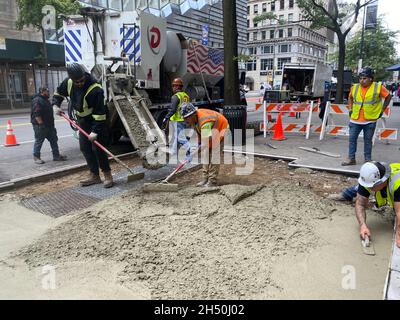 Arbeiter legten einen neuen Bürgersteig entlang der 14th Street in Manhattan, NYC, ein. Stockfoto