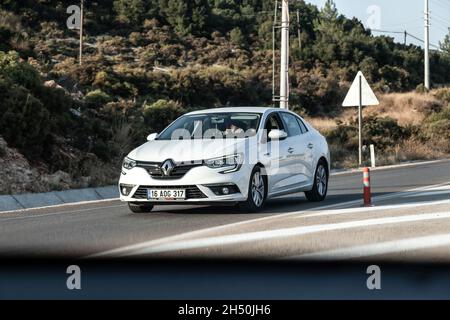 Antalya, Türkei - 08. 25. 2021: Der weiße Renault Megane fährt an einem warmen Sommertag auf der Autobahn vor dem Hintergrund eines Palmengebäudes Stockfoto