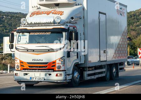 Antalya, Türkei - 08. 25. 2021: Ein weißer Isuzu-LKW-Kühlschrank mit einem großen Lieferwagen, der auf der Autobahn fährt Stockfoto