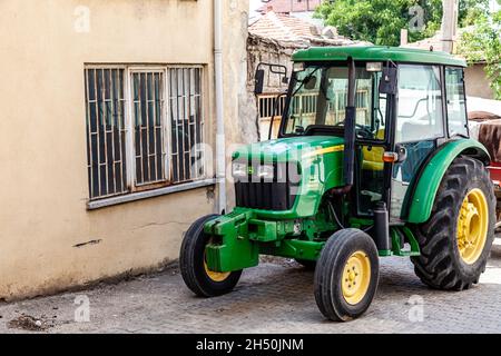 Antalya, Türkei - 08. 25. 2021: John Deere Traktor in der kleinen türkischen Stadt Stockfoto