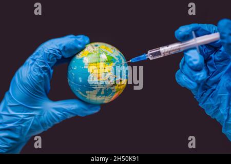 Spritze impft den Globus, auf einer Karte der USA. USA Coronavirus, Corona Virus Angriffskonzept. Amerika kämpft gegen das Coronavirus. Konzept des Kampfes Stockfoto