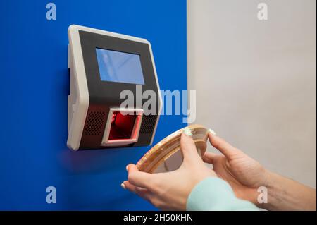 Preisscanner für Barcodes in Nahaufnahme an der Wand in einem Geschäft. Die gesichtslose Käuferin überprüft selbständig den Wert der Ware. Stockfoto