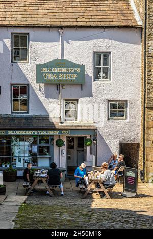 Essen im Freien auf den Kopfsteinpflaster vor einem Café in der Upland Pennines-Stadt Alston, Cumbria, Großbritannien Stockfoto