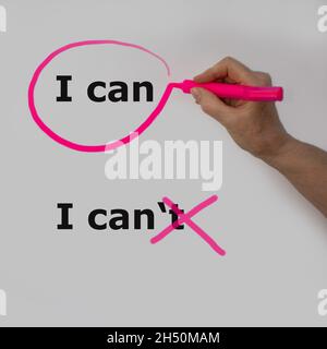 Die Worte, die ich kann, sind mit einem rosa Bleistift von einer Hand mit einer Blase eingekreist, die Worte, die ich kann, sind durchgestrichen Stockfoto