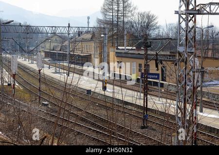 Zakopane, Polen - 23. März 2018: Bahngleise, Gebäude, Fahrleitung und Infrastruktur. Es ist ein Blick auf den Bahnhof, der endet Stockfoto