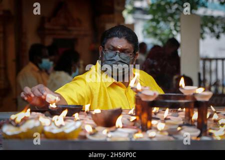 Kuala Lumpur, Malaysia. November 2021. Ein Hindu-Anhänger sah während des Festivals Öllampen anzünden, während er im Tempel der Batu Caves bete.Diwali ist eines der wichtigsten religiösen Feste im Hinduismus. Die Göttin Lakshmi, der gott des Reichtums, wird während Diwali für Glück, Wohlstand und Ruhm verehrt. Kredit: SOPA Images Limited/Alamy Live Nachrichten Stockfoto