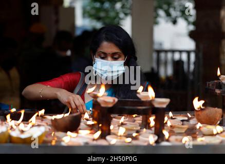 Kuala Lumpur, Malaysia. November 2021. Ein Hindu-Anhänger sah während des Festivals Öllampen anzünden, während er im Tempel der Batu Caves bete.Diwali ist eines der wichtigsten religiösen Feste im Hinduismus. Die Göttin Lakshmi, der gott des Reichtums, wird während Diwali für Glück, Wohlstand und Ruhm verehrt. Kredit: SOPA Images Limited/Alamy Live Nachrichten Stockfoto