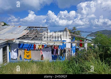 Wäsche vor dem verwüsteten Haus, das durch den Unrufer Irma auf der Insel Tortola, den Britischen Jungferninseln und den Kleinen Antillen in der Karibik zerstört wurde Stockfoto