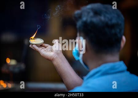 Kuala Lumpur, Malaysia. November 2021. Ein Hindu-Anhänger hält während des Festivals eine Öllampe in der Bete am Tempel der Batu-Höhlen.Diwali ist eines der wichtigsten religiösen Feste im Hinduismus. Die Göttin Lakshmi, der gott des Reichtums, wird während Diwali für Glück, Wohlstand und Ruhm verehrt. (Foto von Wong Fok Loy/SOPA Images/Sipa USA) Quelle: SIPA USA/Alamy Live News Stockfoto