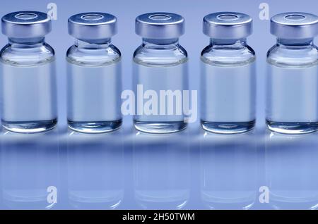 Fläschchen mit flüssigem Medikament als Impfdosis Grippeimpfung zur Injektionsbehandlung auf medizinischem Tisch. Hintergrund Impfungs- oder Impfpflegekonzept. Stockfoto