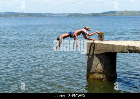 Cachoeira, Bahia, Brasilien - 29. November 2014: Junge Menschen springen vom Deck des Flusses Paraguacu in Barra de Paraguacu in der brasilianischen Provinz Stockfoto