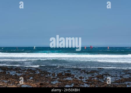 Windsurfer nutzen das perfekte Wetter: Wind und große schaumige Wellen nahe der Südostküste der Insel, El Medano, Teneriffa, Spanien Stockfoto