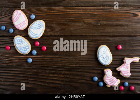 Bonbons, Osterklätzchen in Form von Hühnchen und Kaninchen auf Holztisch Hintergrund. Flaches Lay-Mockup mit Kopierplatz. Stockfoto