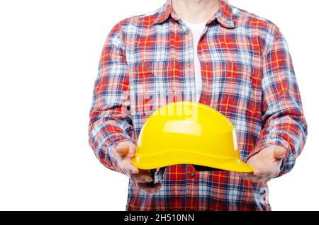 Ein kaukasischer Arbeiter mittleren Alters hält einen gelben Hut in den Händen auf weißem Hintergrund Stockfoto