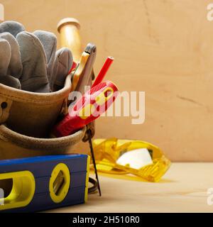 Nahaufnahme am Werkzeuggürtel mit Tischlerwerkzeugen und Schutzbrille Stockfoto