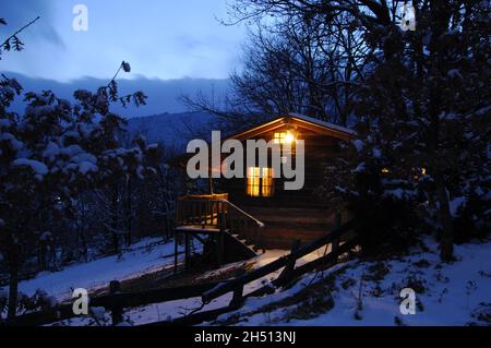 Verstecktes Holzhaus im verschneiten Wald. Schöne idyllische verschneite Landschaft.Griechenland, Europa Stockfoto