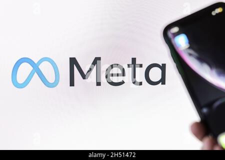 Taschkent, Usbekistan - 29. Oktober 2021: Konzept von Facebook, das den Namen in Meta ändert. Die Hand hält das Smartphone mit dem Facebook-Logo über dem New META-Logo Stockfoto