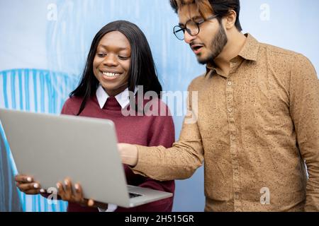 Zwei multirassische Studenten beobachten einige auf dem Laptop Stockfoto