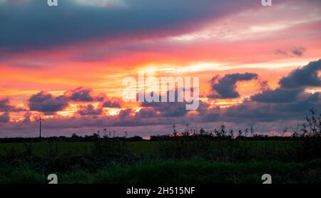 Portreath, Cornwall, Großbritannien, 5. November 2021, die Sonne konnte in ihrer ganzen Pracht gesehen werden, als sie über St. Minver in Cornwall nach einem sonnigen Tag unterging. Der Himmel wurde in ein herrliches Rot und Pink verwandelt.Quelle: Keith Larby/Alamy Live News Stockfoto