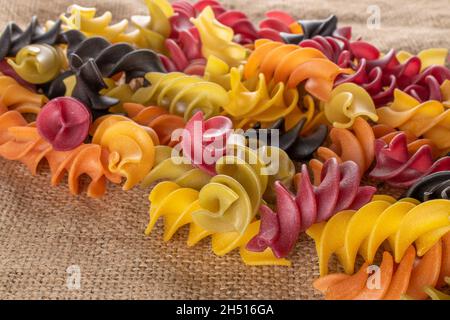 Rohe, farbige Fusilli-Pasta auf dem Sacken, Nahaufnahme. Stockfoto