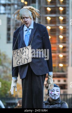 Westminster, London, Großbritannien. November 2021. Ein Protestler posiert als Boris Johnson mit dem Parlament im Hintergrund. Die Demonstranten des jährlichen Millionen-Maske-Marsches mischen sich heute Nachmittag und Abend auf dem Parliament Square in Westminster mit Anti-Lockdown- und Anti-Impfdemonstranten, einige auch in Guy Fawkes-Masken. Es werden Flare und einige Feuerwerke angezündet, was die Polizei dazu veranlasst hat, eine vorsichtige Haltung einzunehmen, mit einer starken Polizeipräsenz in Westminster heute Abend. Kredit: Imageplotter/Alamy Live Nachrichten Stockfoto