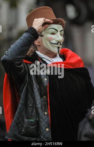 Westminster, London, Großbritannien. November 2021. Die Demonstranten des jährlichen Millionen-Maske-Marsches mischen sich heute Nachmittag und Abend auf dem Parliament Square in Westminster mit Anti-Lockdown- und Anti-Impfdemonstranten, einige auch in Guy Fawkes-Masken. Es werden Flare und einige Feuerwerke angezündet, was die Polizei dazu veranlasst hat, eine vorsichtige Haltung einzunehmen, mit einer starken Polizeipräsenz in Westminster heute Abend. Kredit: Imageplotter/Alamy Live Nachrichten Stockfoto