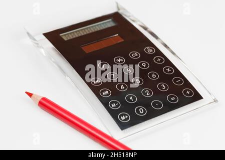 Schwarzer Taschenrechner aus Acrylglas mit integrierter Tastatur und rotem Stift Stockfoto