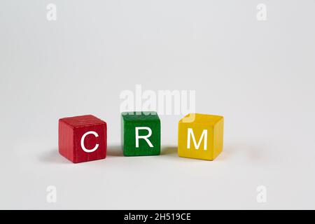 Die Buchstaben CRM stehen für Customer Relationship Management. Diese Buchstaben sind weiß auf roten, grünen und gelben Blöcken geschrieben Stockfoto