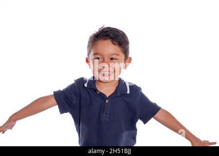 Kind lacht. Schöner lateinischer Junge, der lachend und seine Arme öffnend, isoliert auf weißem Hintergrund. Stockfoto