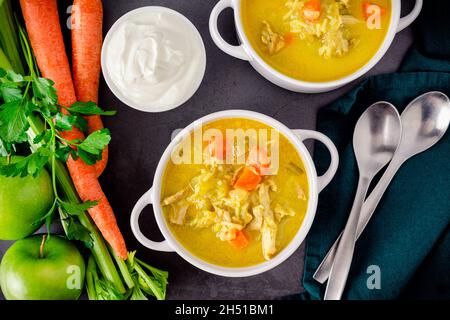 Schüsseln Hühnersuppe mit Mulligatawny: Indische Hühnersuppe mit Curry, Gemüse und Äpfeln Stockfoto