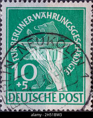 DEUTSCHLAND, Berlin - UM 1949: Eine Briefmarke aus Deutschland, Berlin in grüner Farbe mit einer Opferschale vor dem Berliner Bären. Spendenpos. Stockfoto