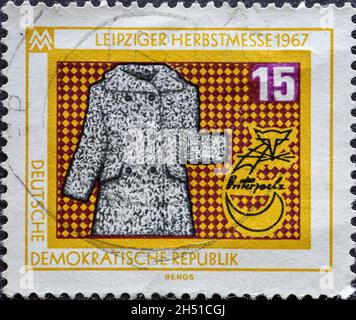 DEUTSCHLAND, DDR - UM 1967: Eine Briefmarke aus Deutschland, DDR mit Pelzmantel für die Leipziger Herbstmesse 1967 Stockfoto