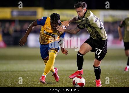 Die Kreuzfahrt Nyadzay von AFC Sudbury im Einsatz mit Cameron Coxe von Colchester United während des ersten Spiels des Emirates FA Cup im MEL Group Stadium, Sudbury. Bilddatum: Freitag, 5. November 2021. Stockfoto