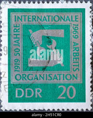 DEUTSCHLAND, DDR - UM 1969: Eine Briefmarke aus Deutschland, DDR, die Hände mit Schraubenschlüssel zeigt. Text: 50 Jahre internationale Arbeitsorganisation Stockfoto