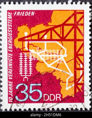 DEUTSCHLAND, DDR - UM 1973 : eine Briefmarke aus Deutschland, DDR zeigt das Energienetz der sozialistischen Länder, Hochspannungsmast. 10 Jahre U Stockfoto