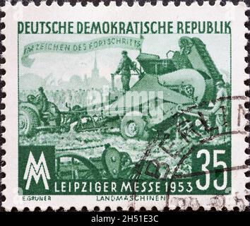 DEUTSCHLAND, DDR - UM 1953 : eine Briefmarke aus Deutschland, DDR zeigt das Messegelände, Kartoffelhebemaschine. Leipziger Herbstmesse Stockfoto