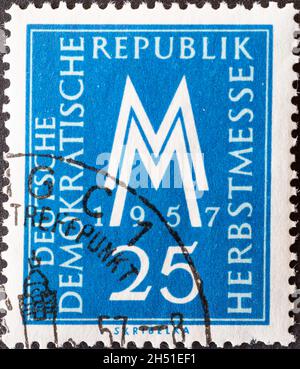 DEUTSCHLAND, DDR - UM 1957 : eine Briefmarke aus Deutschland, DDR zeigt MM das Messesymbol der Leipziger Herbstmesse 1957. Blau Stockfoto