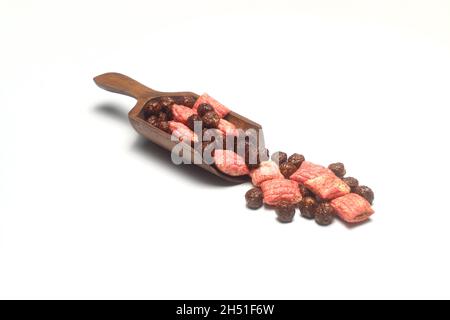 Gesundes Müsli und Cornflakes Frühstück. Gemischter Müsli aus Holzschaufel isoliert auf weißem Grund. Stockfoto