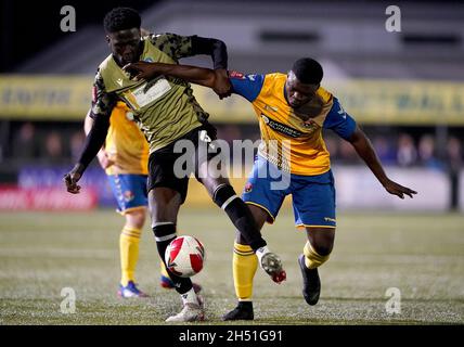 Die Kreuzfahrt Nyadzay von AFC Sudbury im Einsatz mit Brendan Sarpong-Wiredu von Colchester United während des ersten Spiels des Emirates FA Cup im MEL Group Stadium, Sudbury. Bilddatum: Freitag, 5. November 2021. Stockfoto