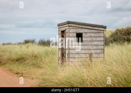 Eine Holzhütte zur Sicherheit vor Ebbe und Flut in einer wilden Dünenlandschaft auf der Spurn Point Insel Stockfoto