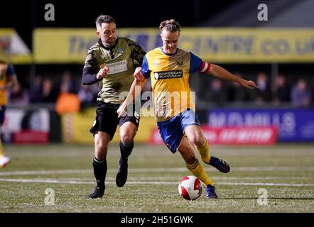 Lewis O'Malley von AFC Sudbury im Einsatz mit Colchester United, Cole Skuse, während des ersten Spiels des Emirates FA Cup im MEL Group Stadium, Sudbury. Bilddatum: Freitag, 5. November 2021. Stockfoto