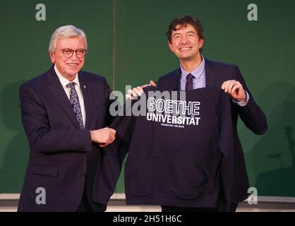 Frankfurt, Deutschland. November 2021. 05. November 2021, Hessen, Frankfurt/Main: Der hessische Ministerpräsident Volker Bouffier (CDU, l) überreicht dem Virologen und Laudator des Abends Christian Drosten nach der Verleihung des Hessischen Kulturpreises im Audimax des Universitätsklinikums Frankfurt ein Kapuzenpullover mit der Aufschrift „Goethe-Universität Frankfurt am Main“. Foto: Frank Rumpenhorst/dpa Quelle: dpa picture Alliance/Alamy Live News Stockfoto