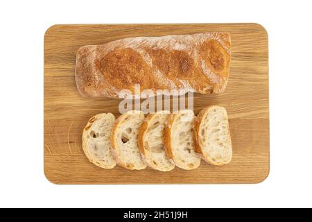 Knuspriges Baguette auf Holzbrett isoliert auf weißem, geschnittenem frischem Brot, Essen, Diät, appetitliches Konzept, Draufsicht Stockfoto