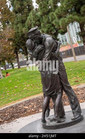 San Diego, Kalifornien, USA - 4. Oktober 2021: Embarcadero-Promenade. Die Statue von Homecoming in grüner Umgebung, die Matrosen und Ehefrau in Umarmung zeigt. Stockfoto