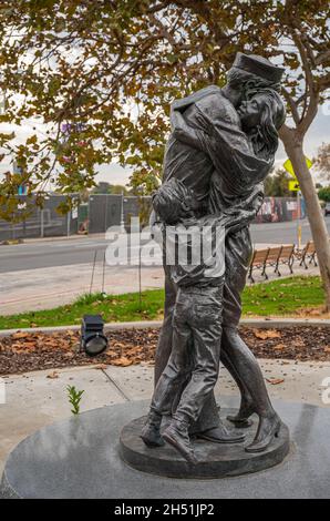 San Diego, Kalifornien, USA - 4. Oktober 2021: Embarcadero-Promenade. Die Statue von Homecoming in grüner Umgebung, die Matrosen, Kinder und Ehefrau in Umarmung zeigt Stockfoto