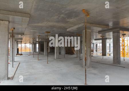 Betonsäulen im Gebäuderahmen. Im Inneren des mehrstöckigen monolithischen Gebäudes. Moderne Konstruktion von Betongebäuden Stockfoto