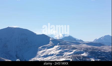 Verschwommener Blick auf die Landschaft des Vulkans Mutnovsky auf der Halbinsel Kamtschatka. Betrachten Sie den Vulkan Mutnovsky als Hintergrund. Stockfoto