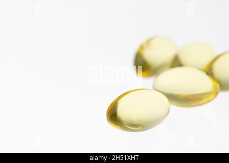 Gruppierung mehrerer Geltabulatoren von Fischöl-, Vitamin D- oder E-Supplementen auf weichem weißem Hintergrund mit Kopierraum Stockfoto