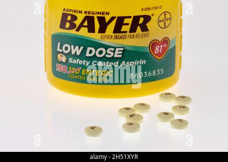 Illustrativer Leitartikel zu niedrig dosierten Aspirin-Flaschen und Pillen von Bayer auf weißem, reflektierendem Hintergrund. Stockfoto